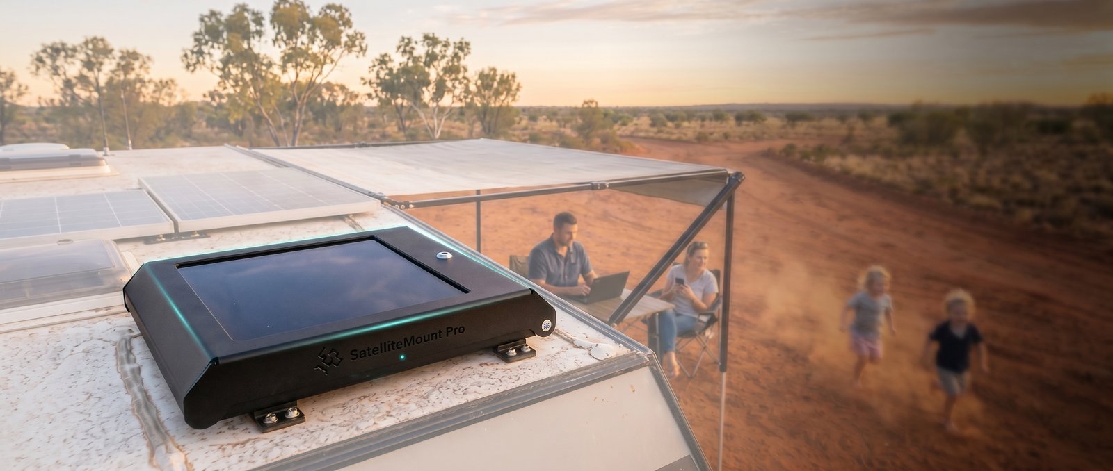 Family at a remote Australian outback campsite at sunset with a SatelliteMount Pro security mount for Starlink Mini installed on their caravan roof
